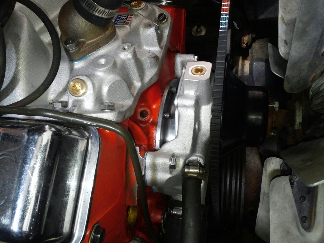 A rebuilt engine bay at Louie's Auto Repair, red block with a freshly fitted water pump and belt